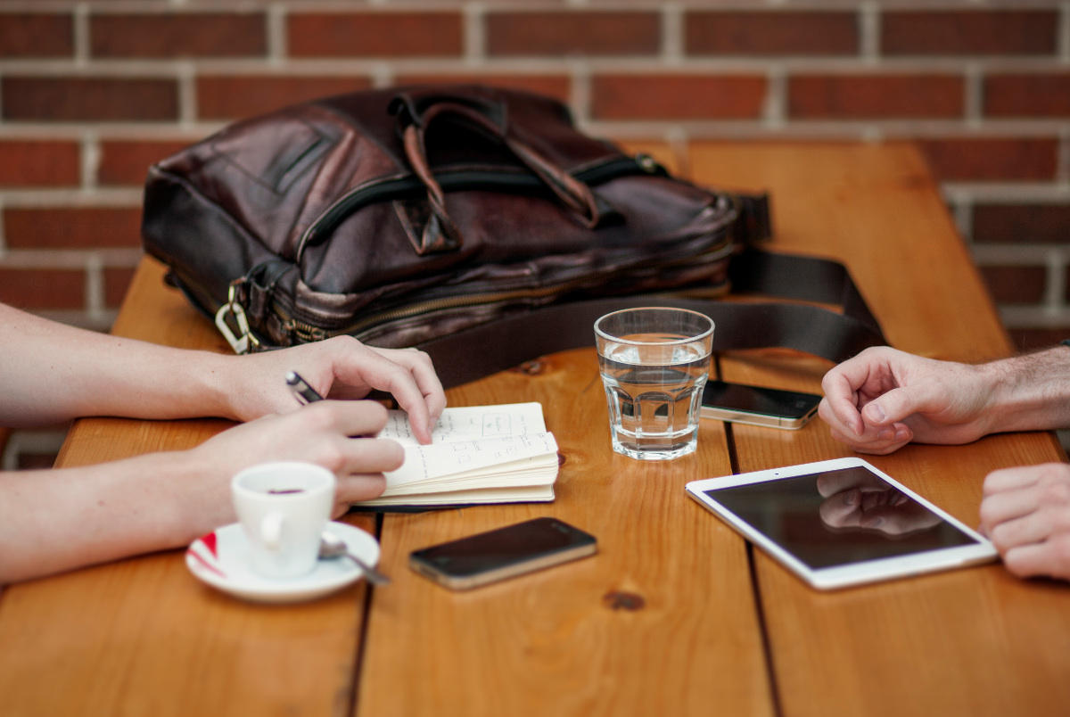 Finding the right mentor can help you fast track your career. Photo of two people meeting at a table. A mentor is a valuable resource to help you advance your career.