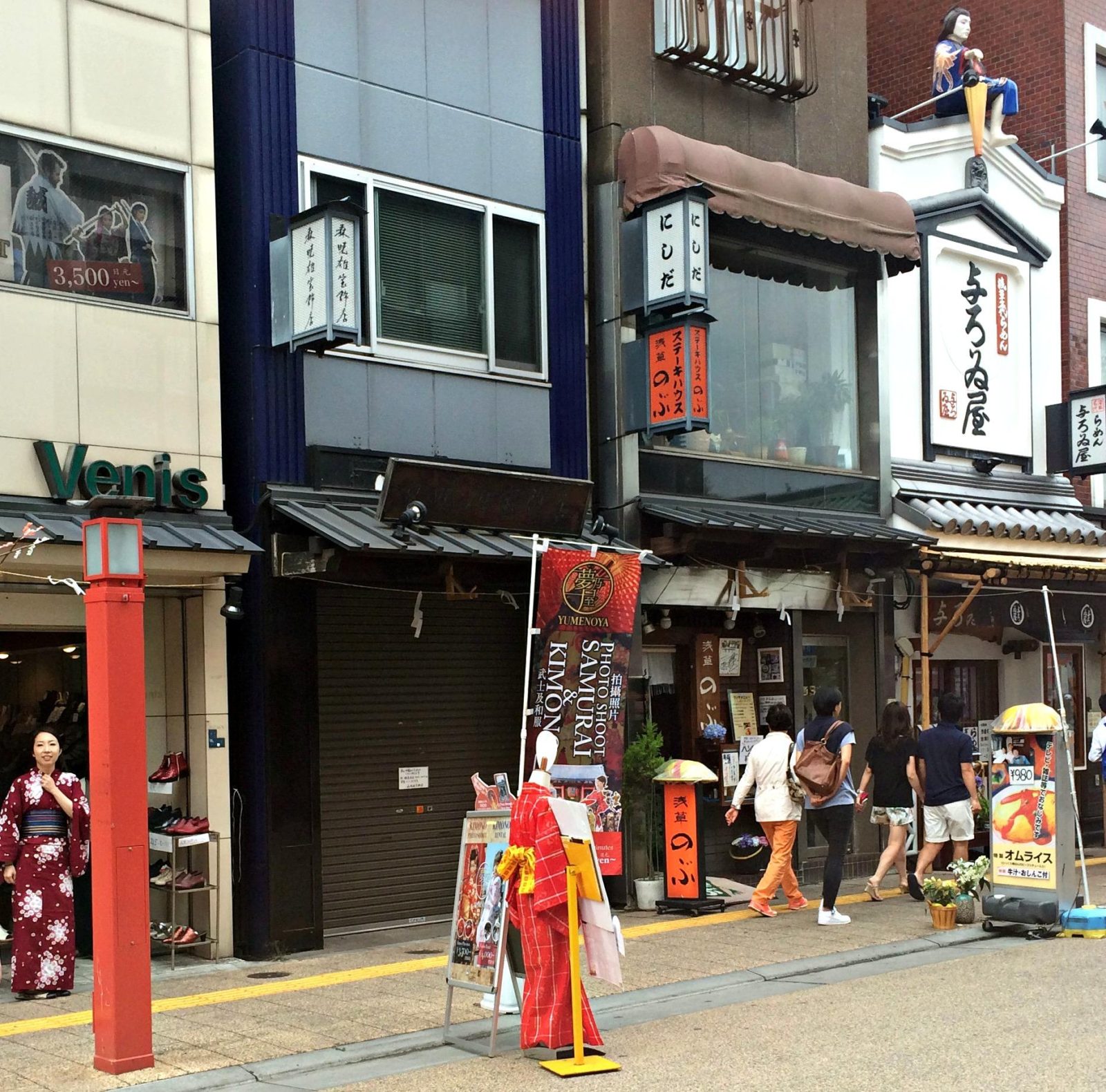 Photo of the outside of a kimono store in Asakusa. A woman wearing a yukata (summer kimono) is in the distance.